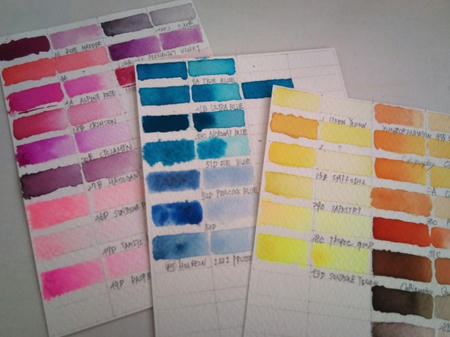 ドクターマーチンのカラーインクで作った手作りの色見本(色チャート)を、白い机に3枚並べて撮影した写真。赤系・青系・黄系の3つに分類されて、3枚の白い紙に各色が乗せられている。