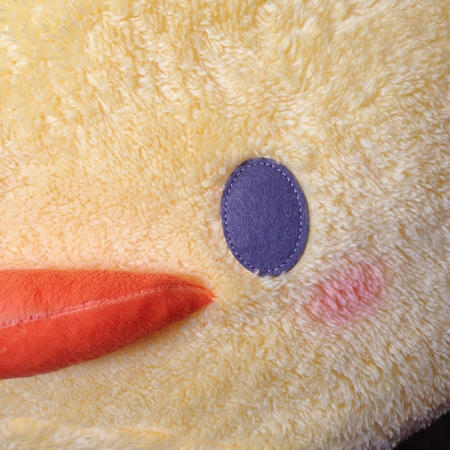 黄色いひよこの抱き枕の目に近づいて撮影した写真。ひよこのぬいぐるみは、「マザーガーデン」のぴよちゃんのジャンボサイズの抱き枕
