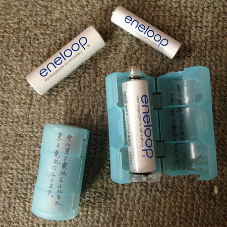 電池アダプター・電池スペーサーという名の水色のプラスチックケースと充電池が一緒に写った画像。電池スペーサーは単三電池や単四電池を単一電池や単二電池に変換できる